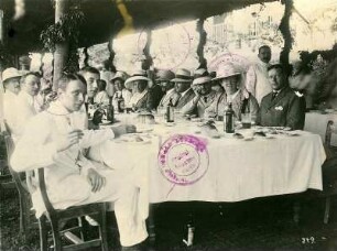 Touristen an einer überdachten Imbißtafel im Freien : Weltreisen. Touristen an einer überdachten Tafel im Freien