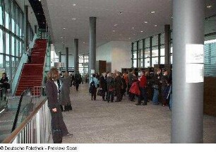 Tagungsteilnehmer an der Garderobe im Foyer