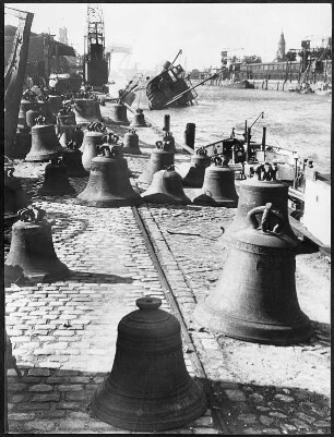 Hamburg. Das Hafenbecken und die Kai´s des Sandtorhafen. Auf dem Kai liegen Glocken, die noch zum Ende des 2. Weltkrieges zum Einschmelzen verschifft werden sollten. Im Hintergrund ein gekentertes Schiff. Aufgenommen 1946