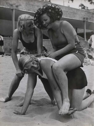 Drei Frauen spielen am Strand