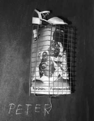 Fahrradkorb mit Plakat zur einer eigenen Ausstellung, Damenschuh, Ritzung in der Wand „Peter“