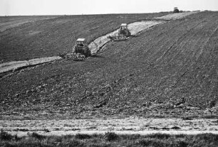 3 Traktoren : Ein großer Acker. Drei Traktoren der LPG pflügen das Feld um