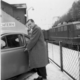 Schlüchtern, Am Bahnhof. Parkplatz. Neben seinem Fahrzeug stehender Mann