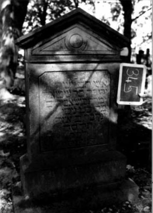 Grabstein 345 (Index: 100111928) Material: Sandstein Zustand: verwittert Maße HxBxT: 120x65x21 cm Beschreibung: Stele, getreppter Sockel, giebelartiger Abschluß mit Verdachung, Schriftfeld eingetieft Symbolik: Kreis: Grabstein 345