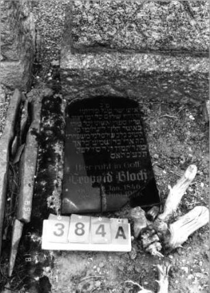 Grabstein 384 (Index: 99797396) Material: Granit, schwarze Glasplatte Zustand: Granit-gut/Platte-stark verwittert Maße HxBxT: 159x56x27 cm Beschreibung: Stele rustiziert, Sockel: Grabstein 384A