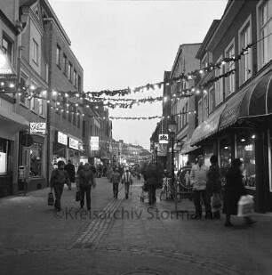 Hindenburgstraße: Passanten in der Fußgängerzone mit eingeschalteter Adventsbeleuchtung, Blick Richtung Westen
