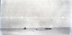 Ein Raddampfer und mehrere Segelschiffe auf dem offenen Meer