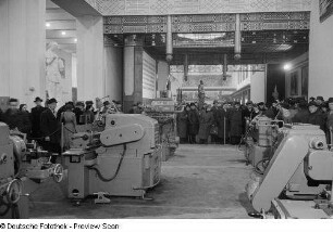 Besucher an einem Messestand mit Maschinen im Ausstellungspavillon von China