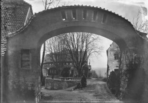 Straßenbild mit Fachwerkhaus. Blick durch einen Torbogen