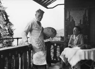 Loschwitzer Porträts. Künstlerpaar. Maler und Textilkünstlerin Margarete Freytag-Just auf einer Veranda vor Wandteppich "Und neues Leben blüht..." (bez. 1965)