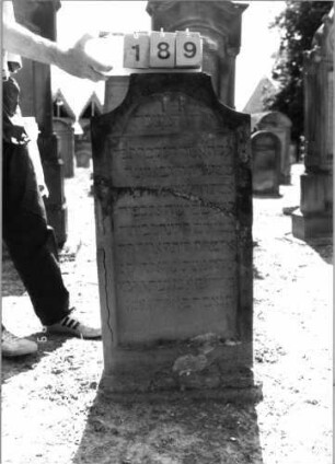 Grabstein 189 (Index: 99797626) Material: Sandstein, rot Zustand: stark verwittert Maße HxBxT: 104x51x8 cm Beschreibung: Stele, geschweifter Abschluß, Sockel: Grabstein 189