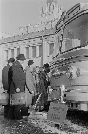 Messebesucher betrachten einen in der UdSSR hergestellten Bus (Mockba). Im Hintergrund der sowjetische Pavillon