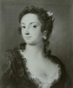 Eine Dame in schwarzem Spitzenkleid mit rosa Schleife