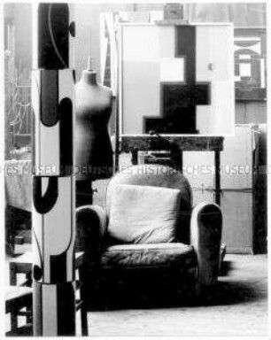 Ein Sessel, eine Staffelei und eine Schaufensterpuppe in einem Atelier