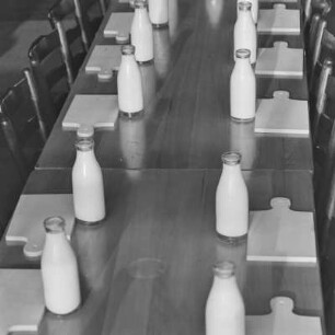 Tisch mit Schneidebrett und einer Flasche Milch in der Kantine von Borgward