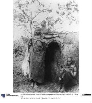 Massai-Frauen mit Messingschmuck vor ihrer Hütte