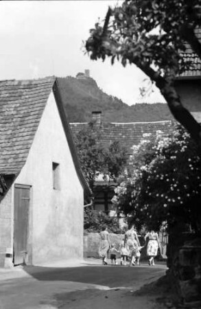 Varnhalt: Dorfstraße mit Gruppe Frauen und Kindern (mit Yburg)
