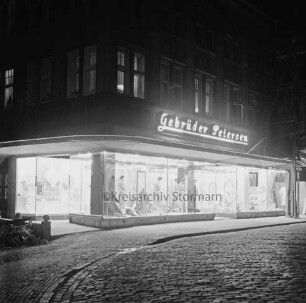 Gebrüder Petersen: Textilhaus: Besttorstraße, Ecke Hude: erleuchtete Schaufenster: darüber Firmenname als Leuchtreklame: im Dunkeln