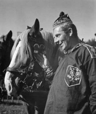 Mann in Tracht und mit Pferd