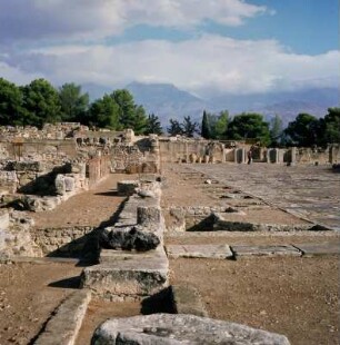 Phaistos. Palast, Mittelhof. Links Kolonniade des Jüngern Palastes. Rechts daneben, verschoben, Steinbasen des Ältern Palastes