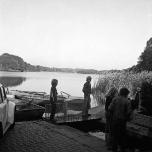 Lütjensee: Bootsteg des Hotels und Restaurants "Fischerklause": vorn Kinder und Erwachsene auf Steg: links Ruderboote