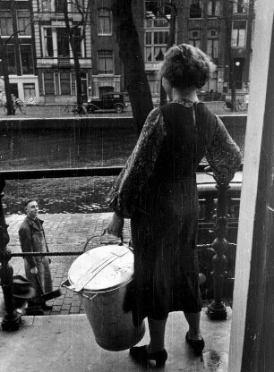Amsterdam. Alltag. Die Müllabfuhr kündigt sich mit einer Knarre an. Die Bewohner bringen dann ihre Müllbehälter zur Straße. Aufgenommen 1936
