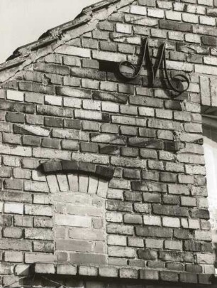 Schleife, Friedensstraße 45. Gehöft. 1921. Nebengebäude. Teilansicht des Straßengiebels mit Ringanker (als Ziermonogramm)