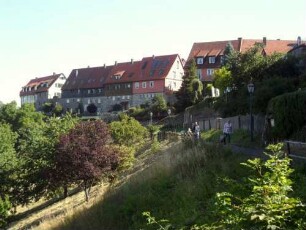Stadtbefestigung - Ansicht im Nordwesten mit Stadtmauerverlauf und neuzeitlich aufgebauten Häusern über Flanke zum Tal