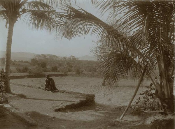 Landschaft mit hockendem Mann