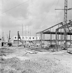 Gewerbegebiet Reinbek/Glinde/Schönningstedt: Bau eines Gewerbebetriebes: Errichtung der Stahlkonstruktion: rechts Baukran: hinten links Baubude und Pkw: dazwischen Baumaterial und Gerüst: im Hintergrund fertige Gebäude