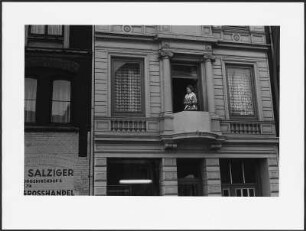 Frau auf einem Balkon stehend, Hamburg, St. Georg
