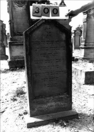 Grabstein 300 (Index: 99797847) Material: Sandstein, weiß Zustand: leicht verwittert Maße HxBxT: 94x47x11 cm Beschreibung: Stele, giebelartiger oben abgeflachter Abschluß, Sockel: Grabstein 300