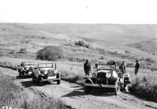 Halt in der Landschaft : Expeditionsteilnehmern neben ihren Fahrzeugen beim Halt in der Landschaft