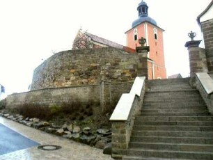 Evangelische Pfarrkirche-Ansicht von Südwesten mit Kirchhofmauer (Wehrgang mit Steinbrüstung sowie Toranlage im 19 Jh abgetragen) und neuzeitlicher Aufgangstreppe