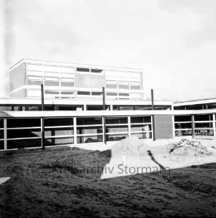 Emil-von-Behring-Gymnasium: Sieker Landstraße: III. Bauabschnitt: Schulgebäude vor Fertigstellung: vorn Sandhaufen und Baumaterial