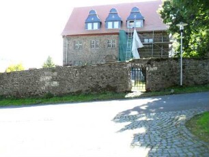 Vogtshof am Marktplatz unterhalb an der Kirche-Ansicht von Ortsseite mit Haupthaus sowie erhaltener Umfassungsmauer mit Schießscharten (Wehrgang mit Steinbrüstung im 18 Jh abgetragen) in Übersicht