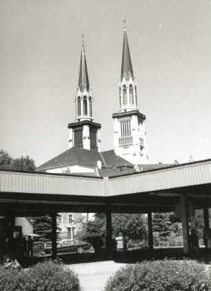 Oelsnitz/Vogtland, Am Jahnteich. Busbahnhof. Überdachte Bahnsteige gegen Türme der Stadtkirche Sankt Jacobi