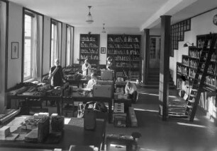 Der Lesesaal des Kunstgeschichtlichen Seminars der Marburger Philipps-Universität während der Vorbereitungen für die Fotokampagne im besetzten Frankreich 1940/41; links stehend Richard Hamann (mit Stativ in der Hand)