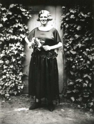 Dame in Ausgehkleid mit Blumenstrauß