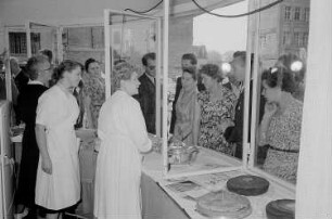 Besucher der Leipziger Herbstmesse 1955 an einem Kiosk mit Kuchen, im Vordergrund drei Verkäuferinnen