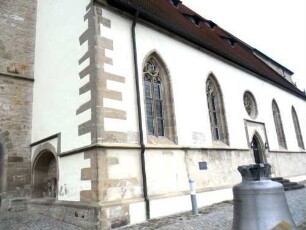 Alexanderkirche - Langhaus von Südwesten über Traufseite Süd mit alter Glocke im Vordergrund