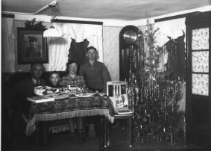 Weihnachten. Familie nach der Bescherung am Tisch im Wohnzimmer