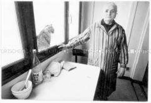 Alte Frau mit Katze am Fenster