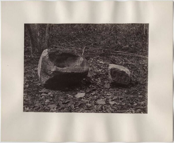 Water trough (pila) and sculpted stone near the wall.