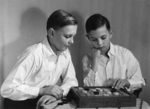 Kinderbilder. Zwei Jungen beim Mühlespielen