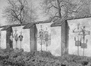 Friedhofsmauer mit Grabkreuzen