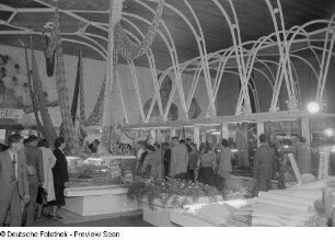 Besucher der Herbstmesse 1953 an Ständen mit Papierwaren sowie Stoffballen