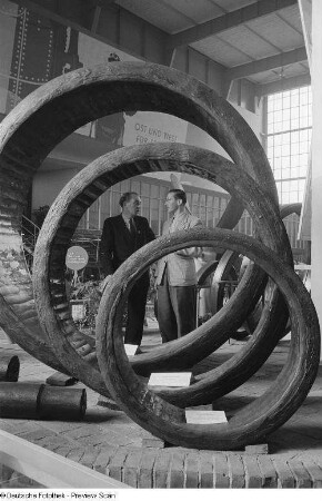 Besucher der Leipziger Herbstmesse 1954 betrachten Zahnkranzbandagen