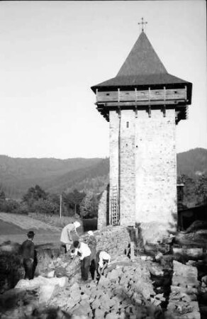 Humor: Kloster, Turm neben der Kirche, Vordergrund Grabenarbeiten