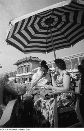 Besucher der Leipziger Messe 1954 beim Verzehren von Brühwurst und Brötchen, im Hintergrund der Chinesische Pavillon